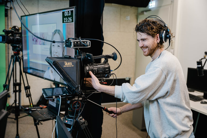Media_Lab_Videoaufnahme_Kamera Ein Mann verwendet die Ausstattung des Media Labs, um ein Video aufzunehmen.
