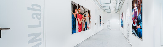 Innovation trifft Design – Einblick in das LEAN Lab einer modernen Hochschule Heller Flur mit großformatigen Fotos und Zugang zum LEAN Lab