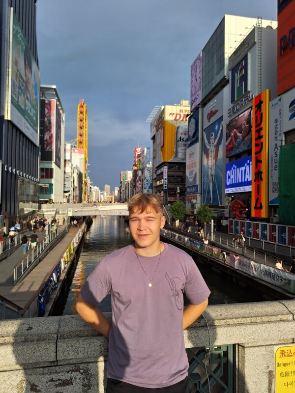 Ein Mann steht auf einer Brücke in einer japanischen Stadt. | © Jacob Lackner