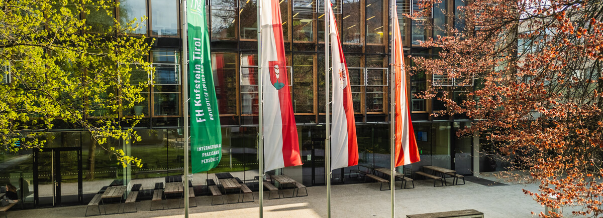 Der Park und das Gebäude der FH Kufstein Tirol mit 4 Flaggen. | © FH Kufstein Tirol