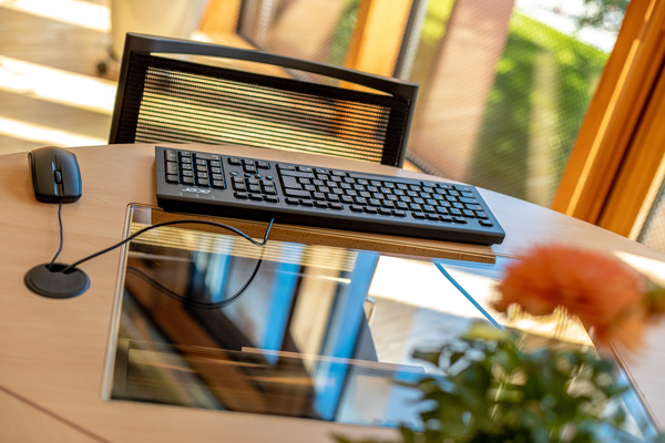 Ein Arbeitsbereich mit einer Maus, Tastatur, und einem Bildschirm der im Tisch eingebaut ist. | © FH Kufstein Tirol