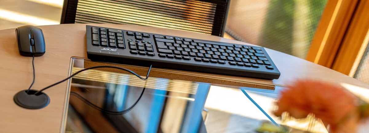 Ein Arbeitsbereich mit einer Maus, Tastatur, und einem Bildschirm der im Tisch eingebaut ist. | © FH Kufstein Tirol