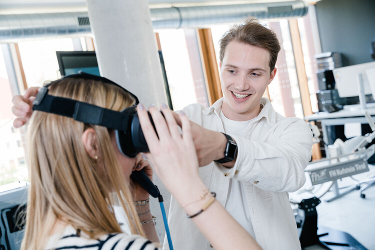 Ein Mann hilft einer Frau, ein Virtual-Reality-Brille aufzusetzen. | © FH Kufstein Tirol