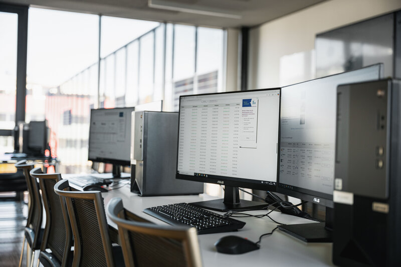 Ein heller und moderner Computerraum mit mehreren Arbeitsplätzen, ausgestattet mit Monitoren, Tastaturen und PCs, in einer Lernumgebung mit großen Fenstern. | © FH Kufstein Tirol