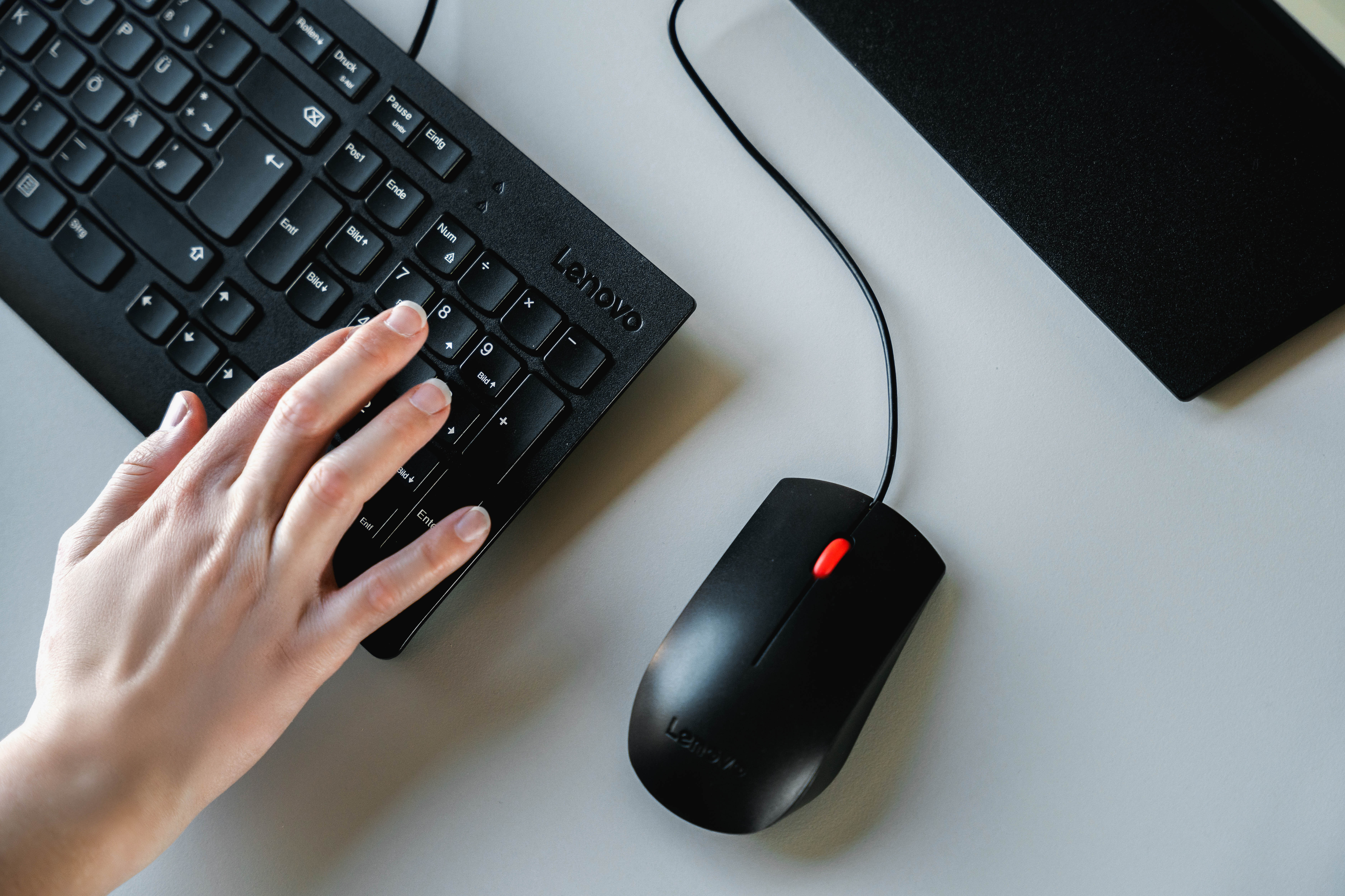 Nahaufnahme einer Hand auf einer Computertastatur; neben der Tastatur eine Computermaus | © FH Kufstein Tirol