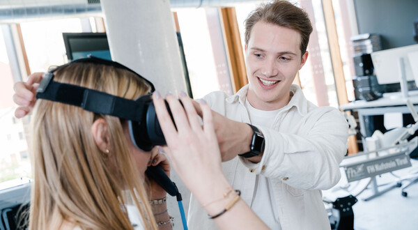 Ein Mann hilft einer Frau, ein Virtual-Reality-Brille aufzusetzen. | © FH Kufstein Tirol