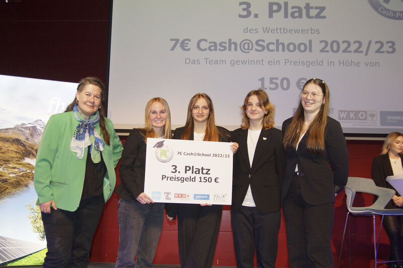 Vier Personen, die bei der 7-Euro-Cash-Veranstaltung den 3. Platz belegen, und die 7-Euro-Cash-Verantwortliche Karin Steiner sind auf der Bühne zu sehen. | © FH Kufstein Tirol