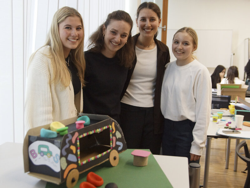 Vier junge Frauen präsentieren ein selbstgebautes Modellfahrzeug in einem Klassenzimmer | © FH Kufstein Tirol