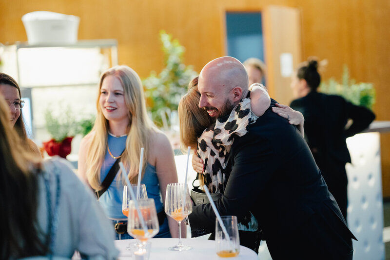 Zu sehen sind fünf Personen, die sich auf dem Homecoming-Event wieder treffen. Sie freuen sich sehr, sich wiederzusehen. | © FH Kufstein Tirol