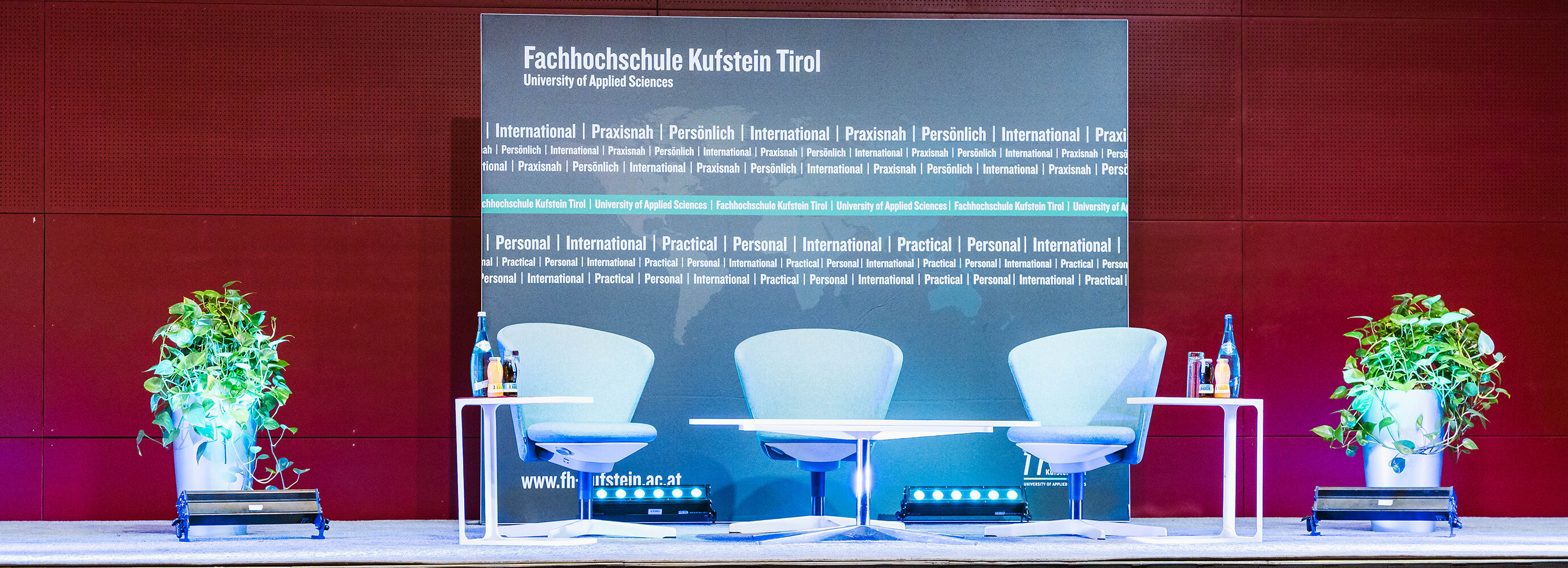 Diskussionspodium mit 3 Sesseln und einer Leinwand im Hintergrund. | © FH Kufstein Tirol