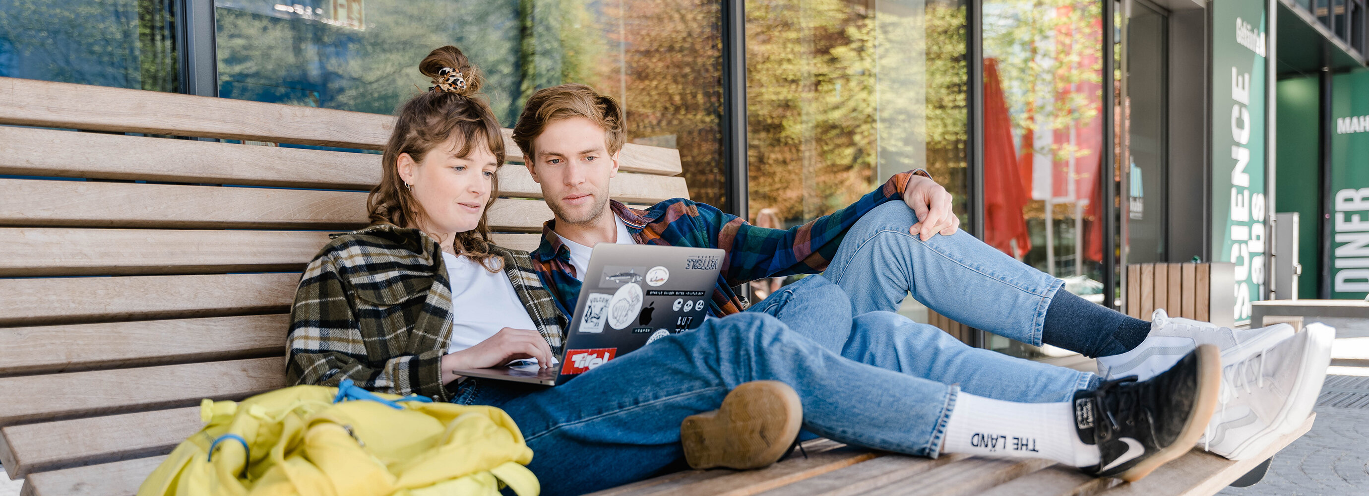 Eine Frau und ein Mann sitzen nebeneinander und sehen sich gemeinsam etwas am Laptop an. | © FH Kufstein Tirol