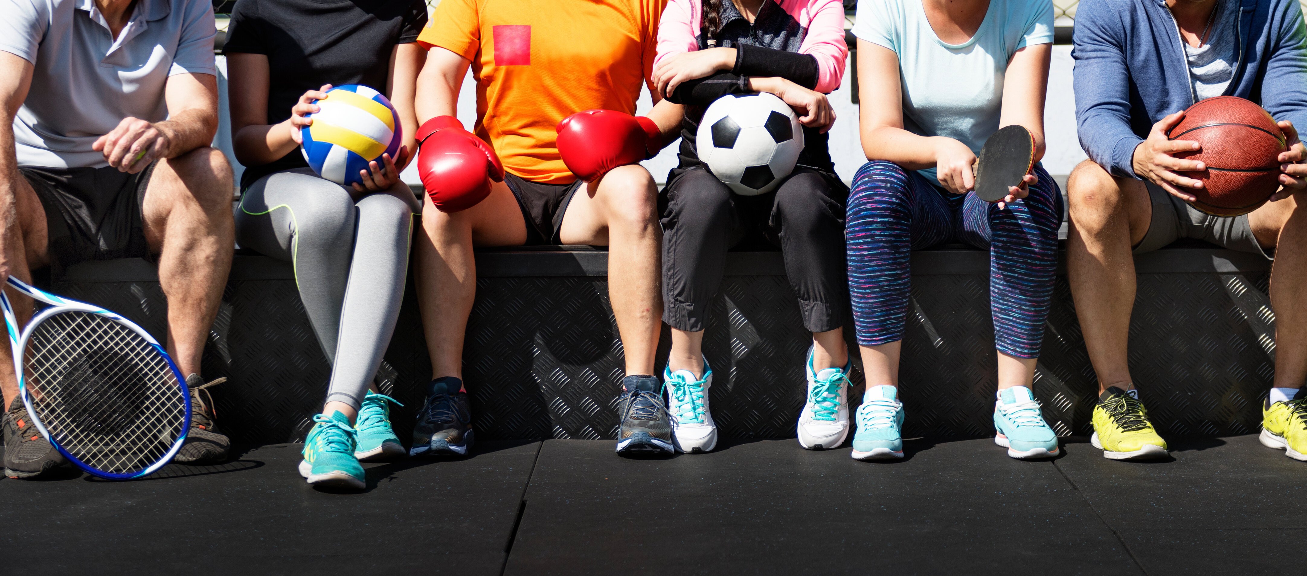 Eine Gruppe von diversen Athleten sitzt zusammen. | © AdobeStock.Rawpixel.com