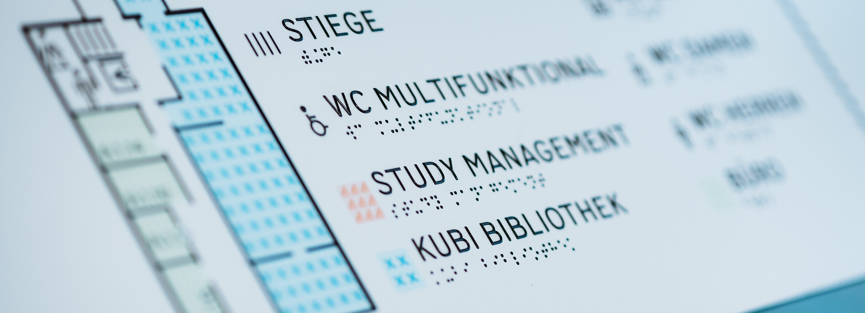 Eine Hinweistafel, welche einen Gebäudeplan der FH Kufstein Tirol abbildet, weist zu jeder Beschriftung auch einen Braille Text auf. | © FH Kufstein Tirol