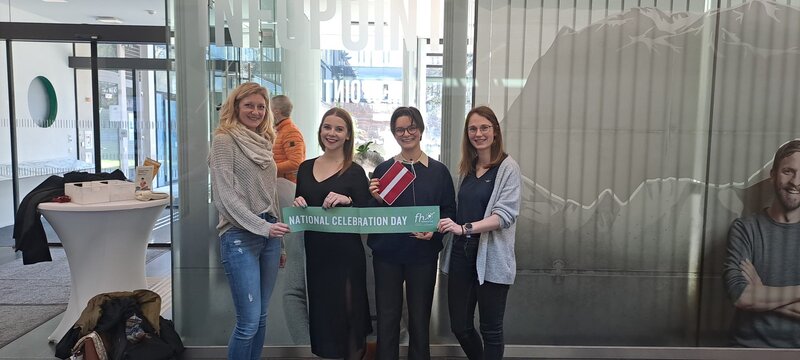 Vier Personen stehen vor dem Info Point mit einem Schild mit der Aufschrift National Celebration Day | © FH Kufstein Tirol