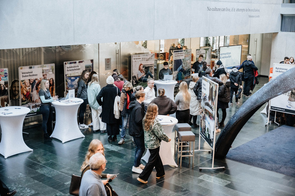 Blick von oben auf die Aula während eines Open House an der FH Kufstein Tirol mit Infoständen und Besucher:innen. | © FH Kufstein Tirol