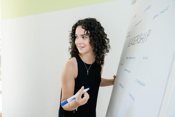 Eine Frau hört einer anderen Person zu, und schreibt Notizen auf ein Whiteboard. | © FH Kufstein Tirol