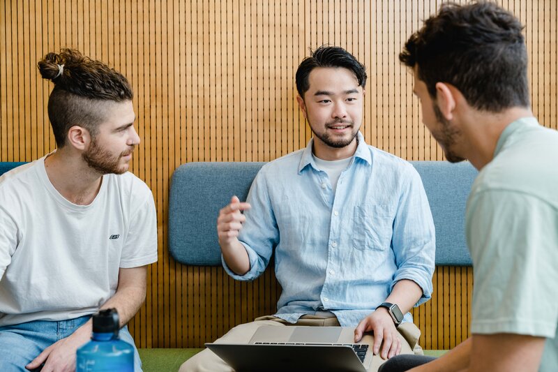 Drei Personen sitzen entspannt und besprechen etwas. Einer der Männer hat einen Laptop auf seinem Schoß. | © FH Kufstein Tirol