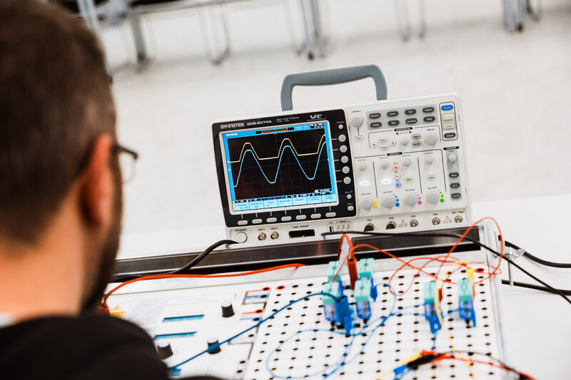 Automation_Lab_Oszilloskop_1 Ein Mann untersucht die Messergebnisse des Oszilloskops.