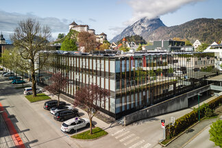 Studieren im Herzen der Alpen – die FH Kufstein Tirol inmitten von Stadt und Natur Luftaufnahme des modernen Hauptgebäudes der FH Kufstein Tirol mit Festung und Bergen im Hintergrund