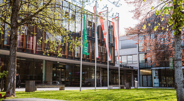 Der Park und das Gebäude der FH Kufstein Tirol mit 4 Flaggen. | © FH Kufstein Tirol